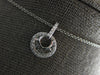 ESTATE .20CT DIAMOND 14KT WHITE GOLD ROUND & BAGUETTE CIRCULAR FLOATING PENDANT
